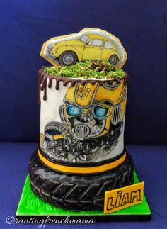 a cake with a yellow car on top and green grass growing out of the bottom