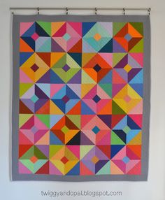 a colorful quilt hanging on the wall