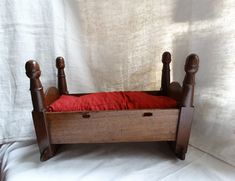 an old wooden bed with red pillows on it