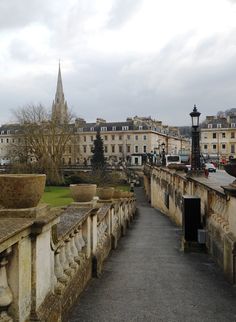 the walkway is lined with stone planters and potted plants on either side of it