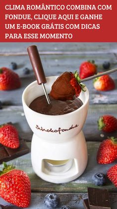 a chocolate fondue in a white bowl with strawberries and chocolate on the side