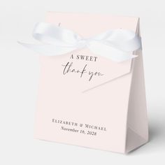 a pink gift bag with a white ribbon tied around the top and thank you written on it