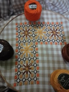 three balls of yarn sitting on top of a table next to two skeins of yarn