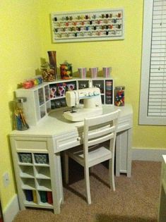 a sewing room with yellow walls and white furniture