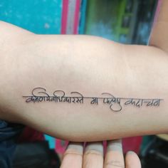 a person with a tattoo on their arm that reads, and the words are in different languages