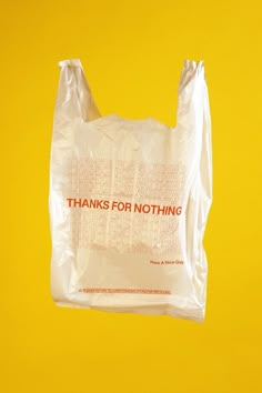 a plastic bag with the words thanks for nothing on it hanging from a yellow background