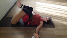 a woman laying on top of a yoga mat