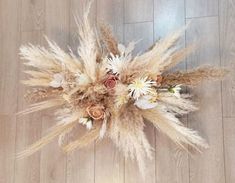 dried flowers are arranged on a wooden floor