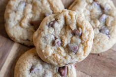 several chocolate chip cookies stacked on top of each other with one cookie in the middle