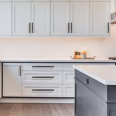 a kitchen with white cabinets and an island