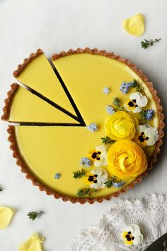 a yellow pie with flowers on top and two black forks in the middle next to it