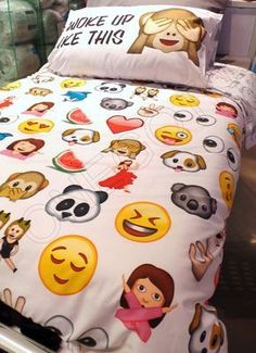 a bed with many emoticions on it and a pillow that says woke up like this