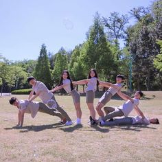 a group of young people standing around each other in the grass with bubbles flying above them