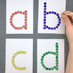 someone is doing something with colored beads on paper