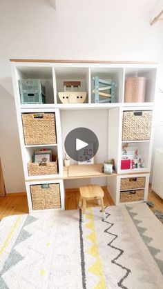 a white bookcase with baskets on top of it and a yellow rug in front of it