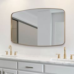 a bathroom with two sinks and a large mirror on the wall above it's counter