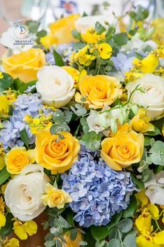 a bouquet of yellow and blue flowers on a table