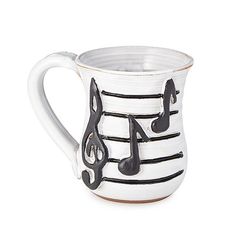 a white and black mug with musical notes on it's side, in front of a white background