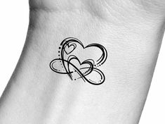 a heart tattoo on the side of a woman's arm with an arrow in it