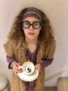 a woman wearing glasses holding a coffee cup