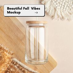 a glass jar filled with liquid sitting on top of a wooden table next to a rug