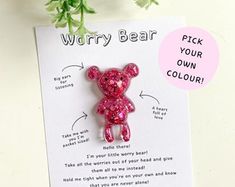 a pink bear brooch sitting on top of a piece of paper