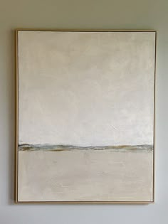 a painting hangs on the wall above a bed in a room with white walls and flooring