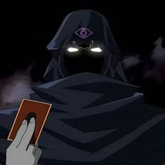 a person holding a book in their hand with an evil looking face on the forehead