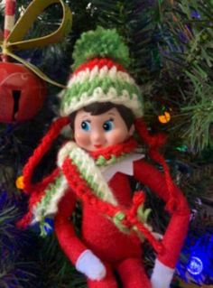 an elf ornament hanging on a christmas tree