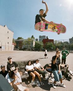 a man flying through the air while riding a skateboard in front of other people