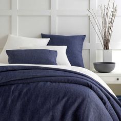 a bed with blue linens and white pillows