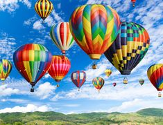 many colorful hot air balloons flying in the sky