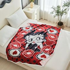 a bed with a red and black blanket on top of it