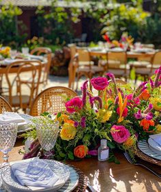 the table is set with flowers and place settings for an outdoor dinner or party event