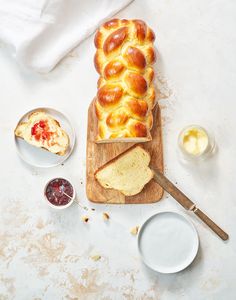 a loaf of bread sitting on top of a wooden cutting board next to two bowls