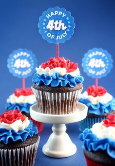 cupcakes decorated with red, white and blue frosting on a cake stand