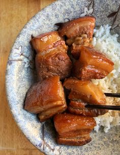 meat and rice on a plate with chopsticks