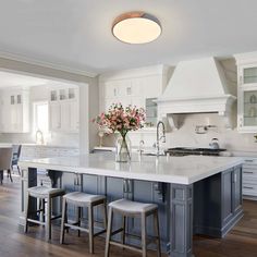 a large kitchen with an island in the middle and two stools next to it