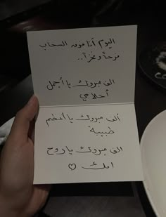 someone holding up two cards with writing on them