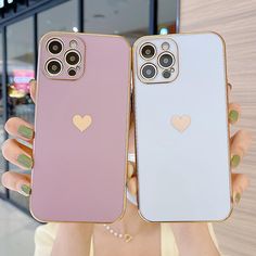 two women holding up their iphone cases with hearts on them