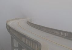 a foggy road with two cars driving on it