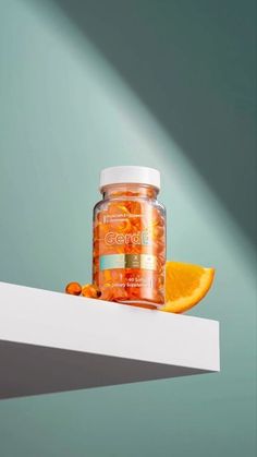 a jar of vitamins sitting on top of a shelf next to an orange slice