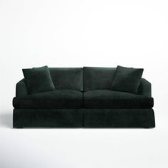 a green couch with two pillows on it and one pillow is folded over the back