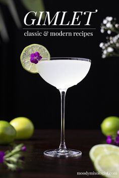 a martini glass filled with white liquid and garnished with a purple flower on the rim