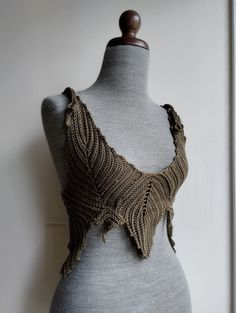 a mannequin wearing a knitted top with crochet details on it