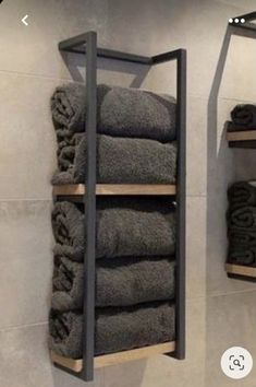 towels are stacked up on shelves in the bathroom, while another shelf holds folded towels