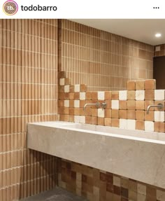 a bathroom with a sink, mirror and tiled wall in it's center area