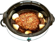 a slow cooker filled with meat and potatoes