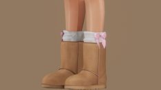 a pair of brown boots with pink bows on them