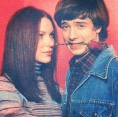 a young man and woman are posing for a photo with a fake moustache on their nose